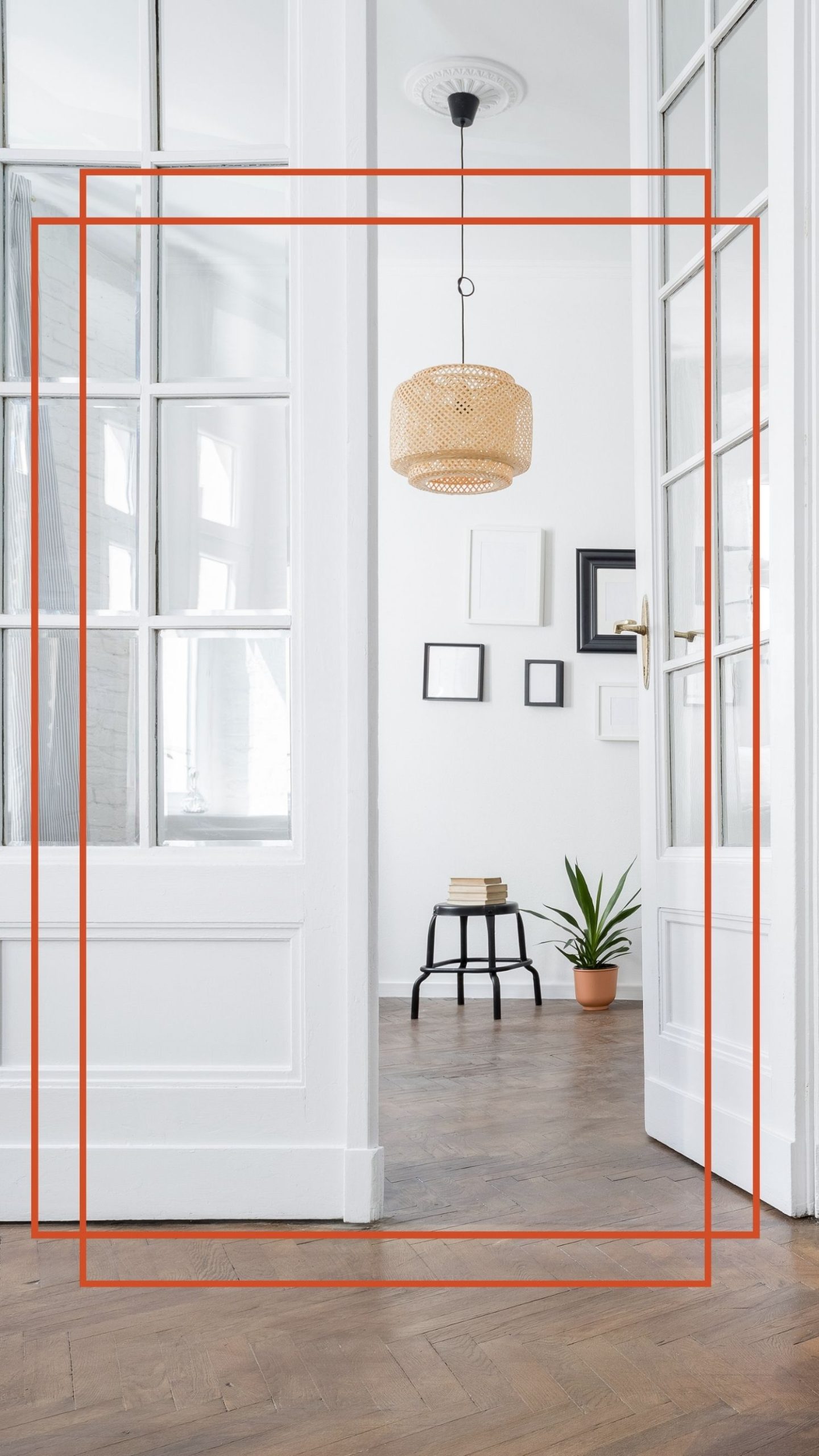 Bright white hallway seen through open French doors, with a woven pendant lamp, framed pictures, a stool and a potted plant on a herringbone wood floor