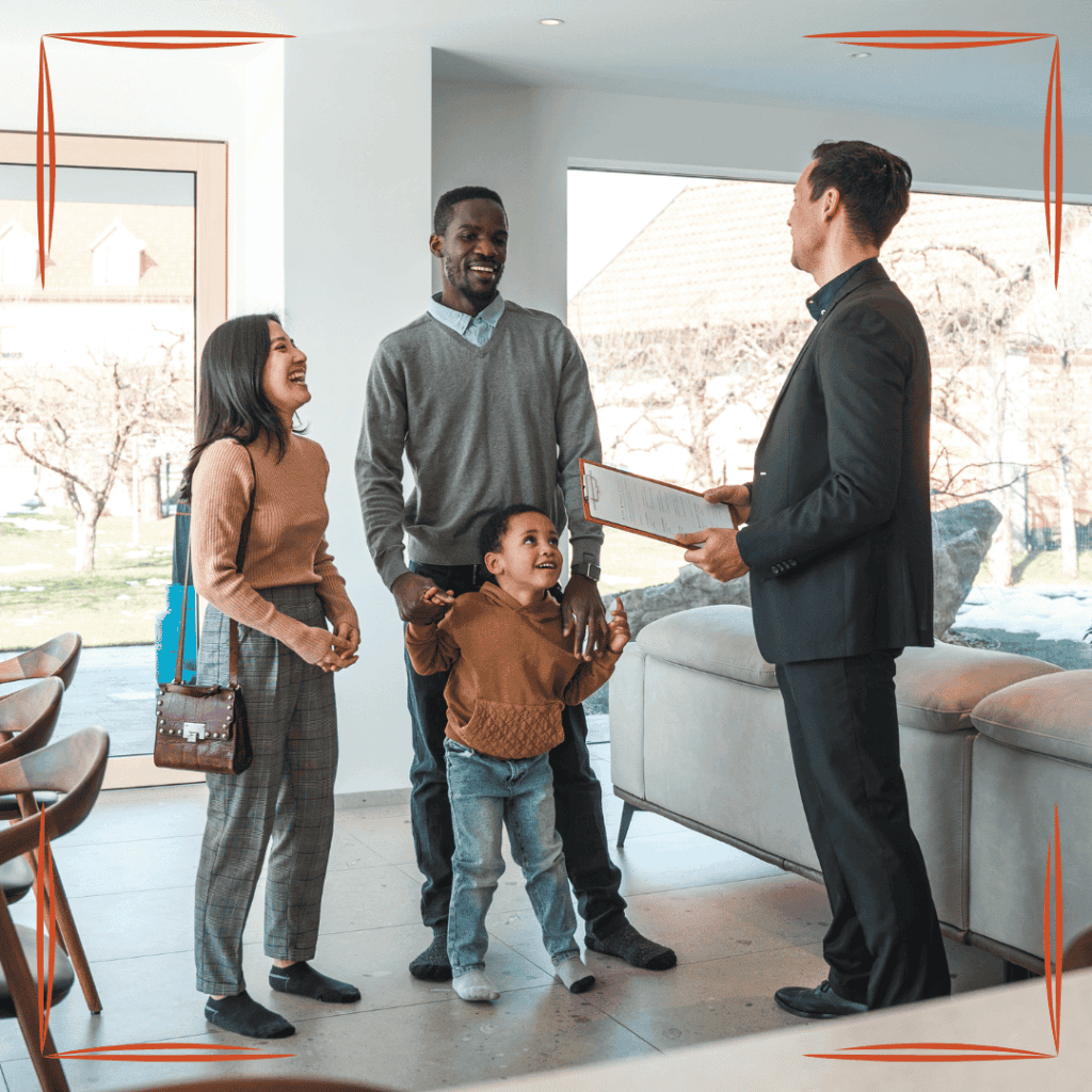 Smiling family with a young child talking with a man holding a clipboard in a bright living room
